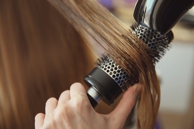 Photo of Professional hairdresser working with client in salon