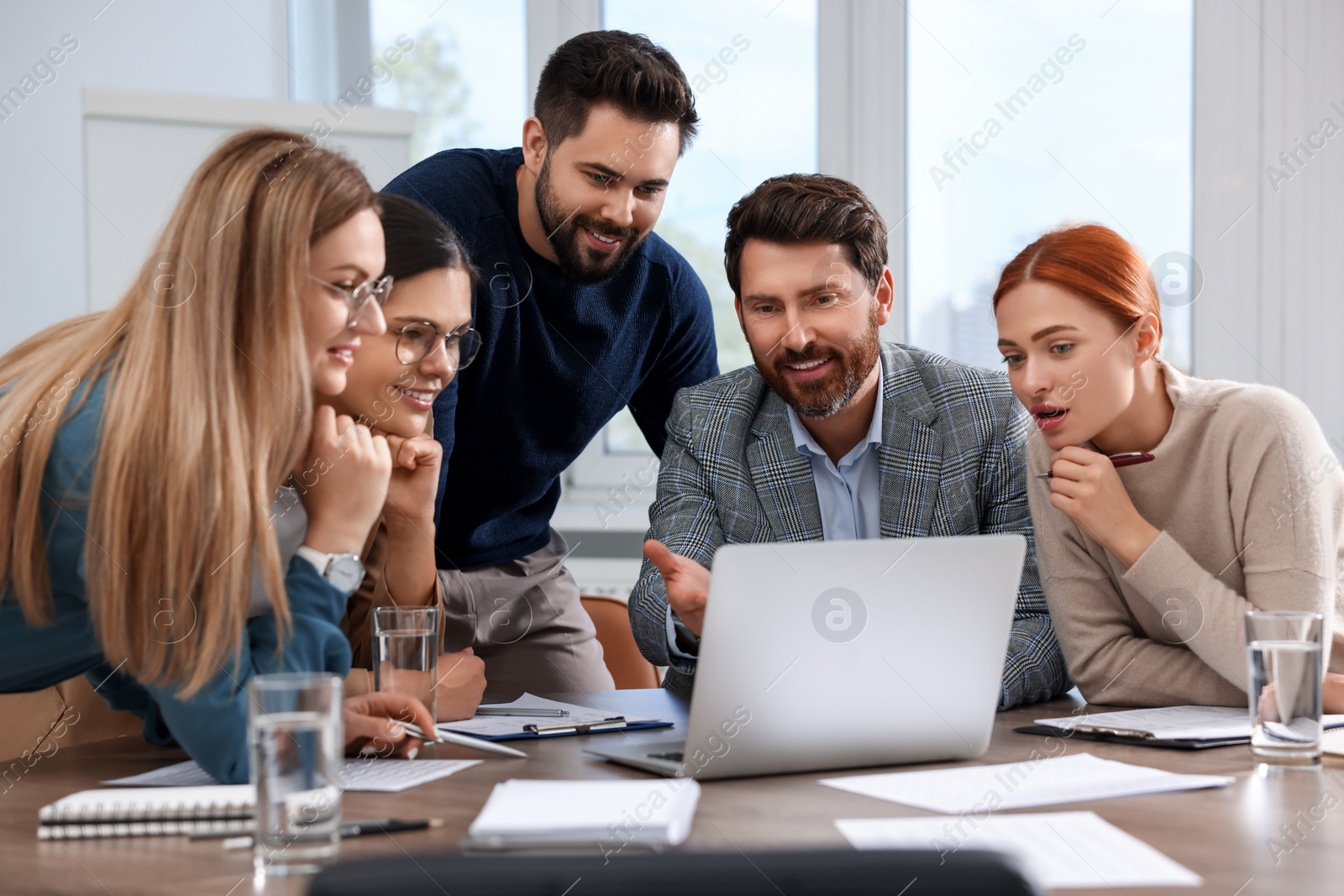 Photo of Team of employees working together in office