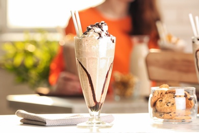 Photo of Glass with delicious milk shake on table indoors