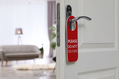 Photo of Open door with sign PLEASE DO NOT DISTURB on handle at hotel, space for text