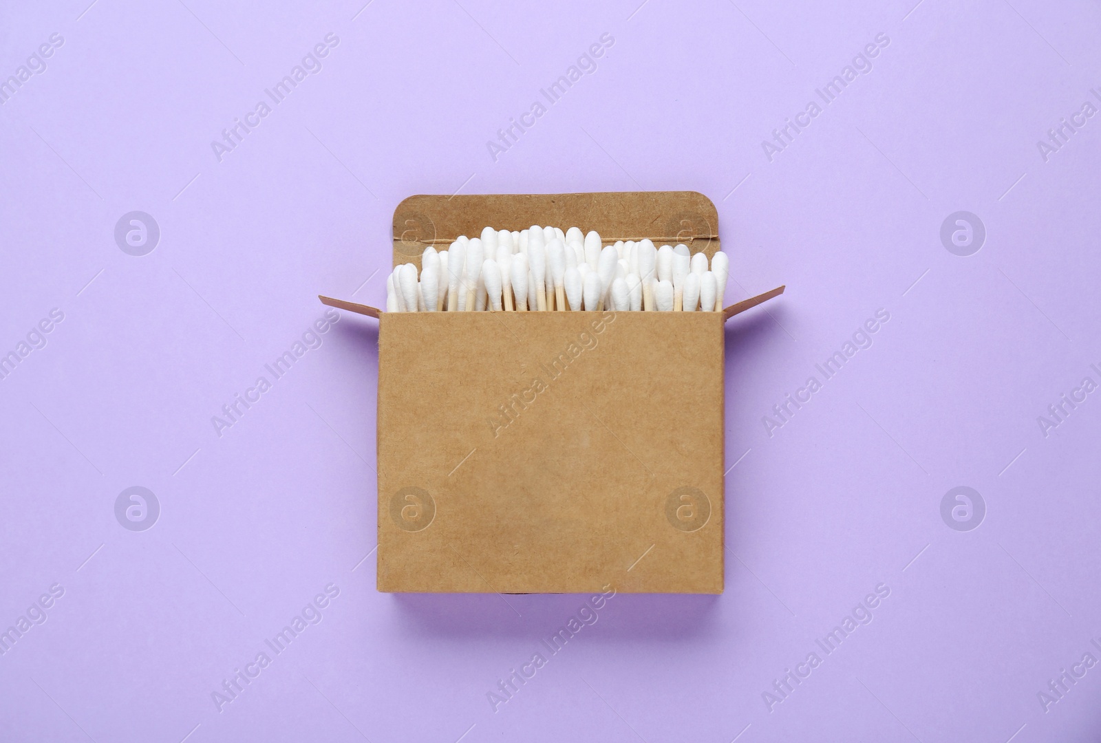 Photo of Box with wooden cotton buds on violet background, top view