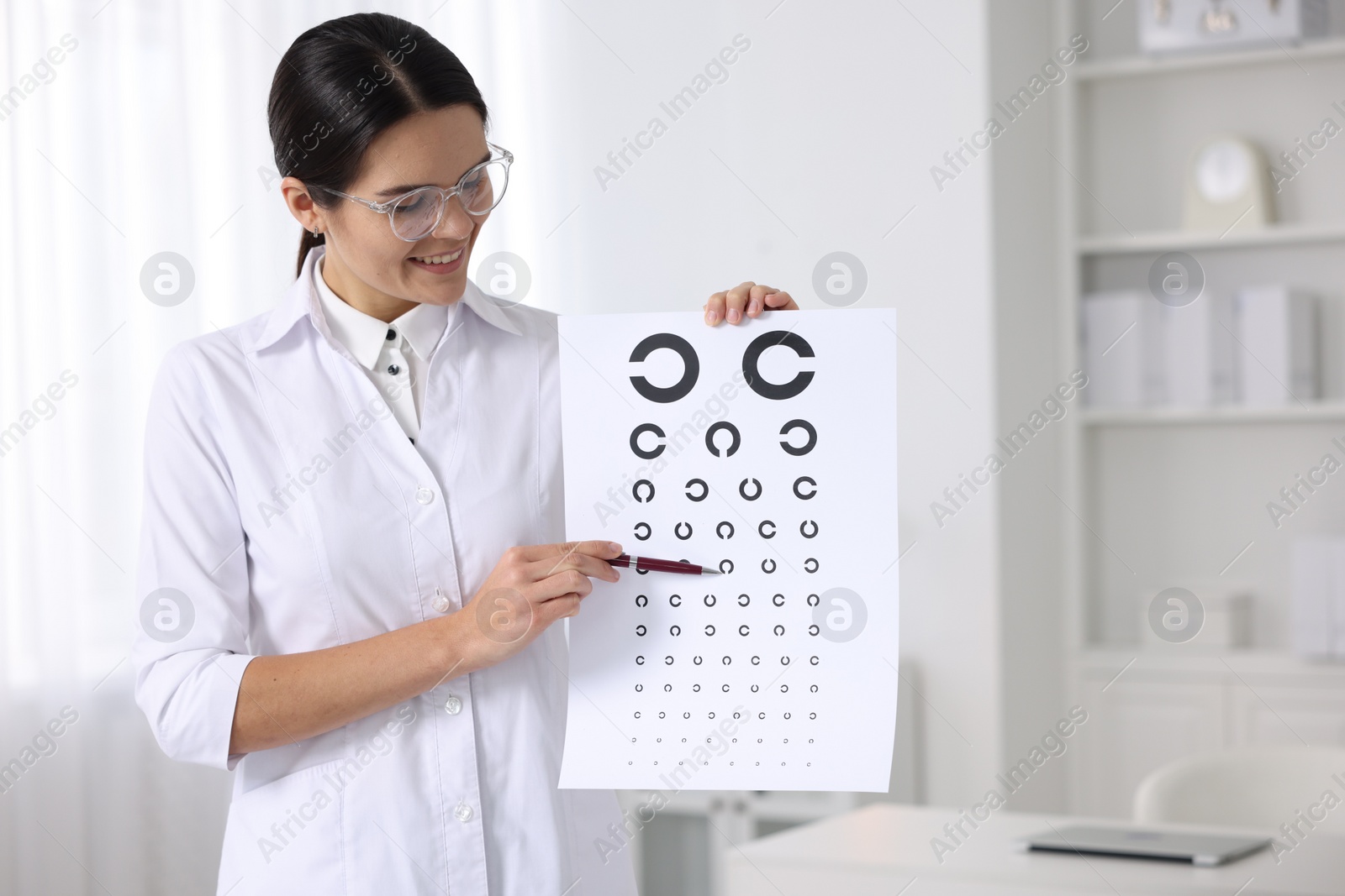 Photo of Ophthalmologist pointing at vision test chart in clinic