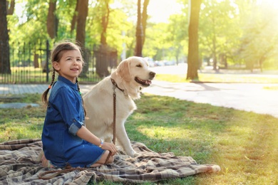 Photo of Cute little child with his pet in green park