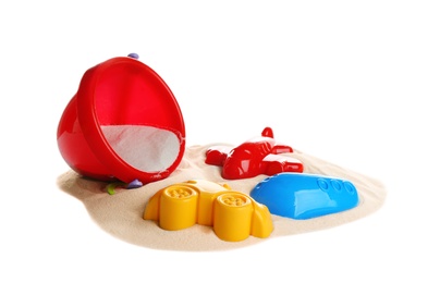 Set of plastic beach toys and pile of sand on white background