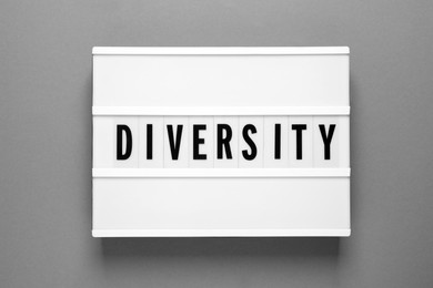 Lightbox with word Diversity on grey background, top view
