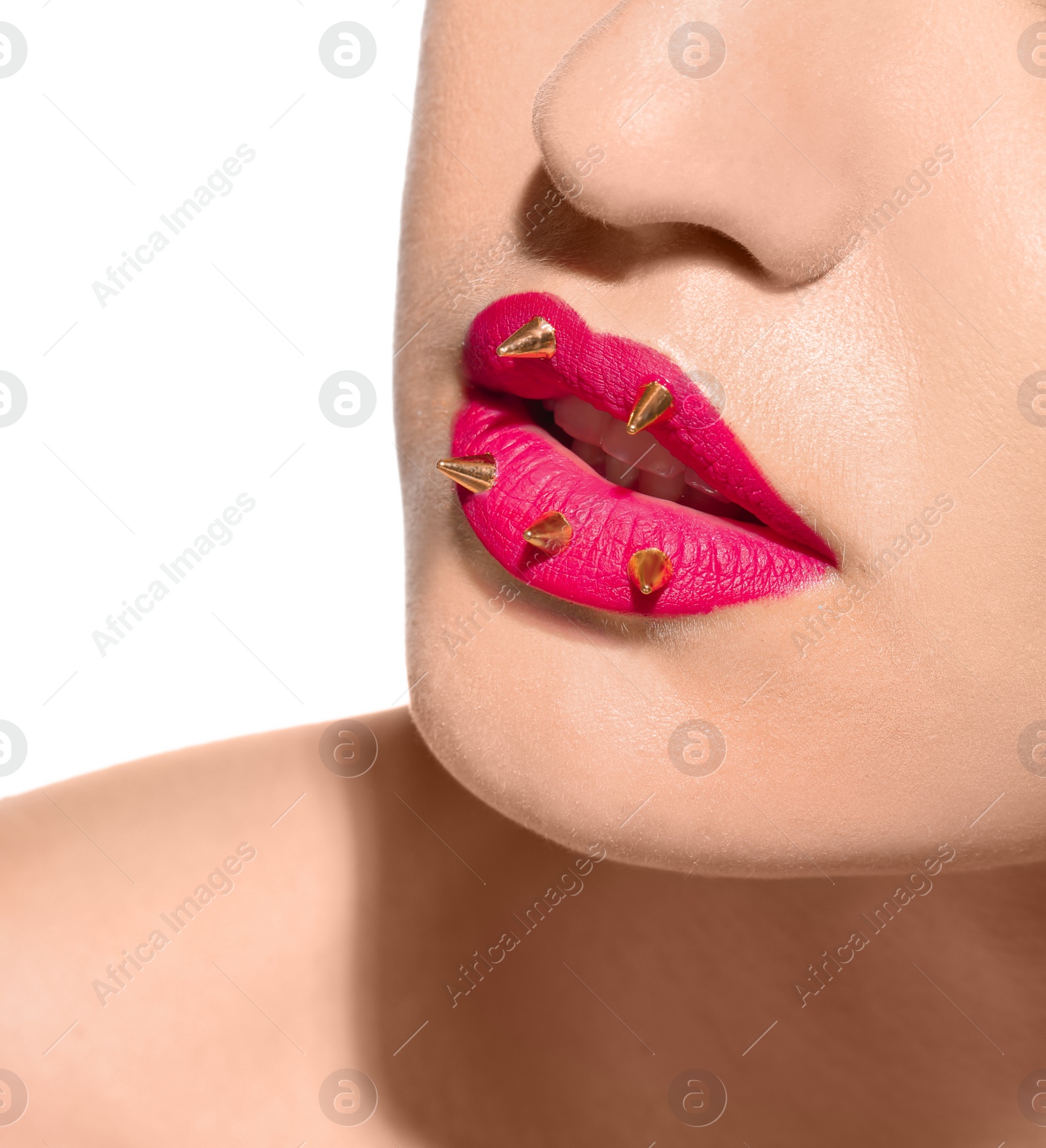 Photo of Beautiful young model with decorative spikes on lips against white background