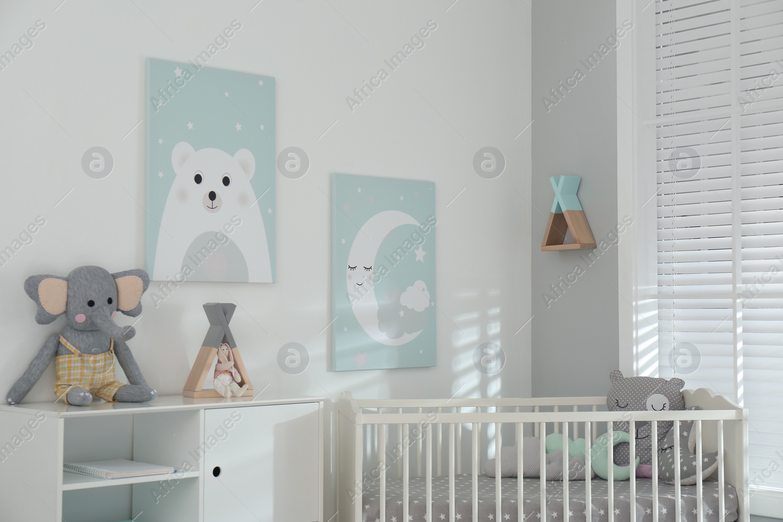 Photo of Stylish baby room interior with crib and cute wall art