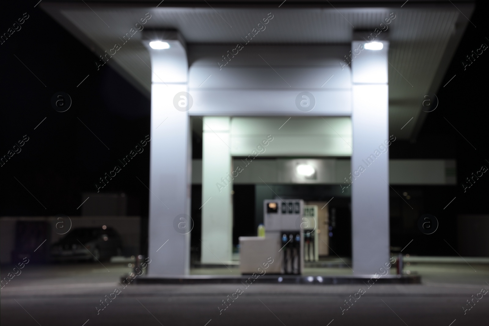 Photo of Blurred view of modern gas station with convenience store beside the road at night