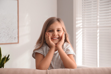 Photo of Cute little girl on couch at home