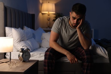 Frustrated man suffering from insomnia on bed