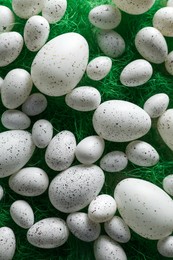 Photo of Many beautifully painted Easter eggs on green background, flat lay