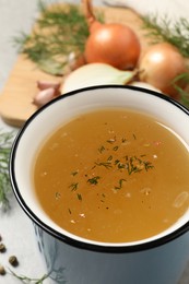 Hot delicious bouillon with dill in cup, closeup