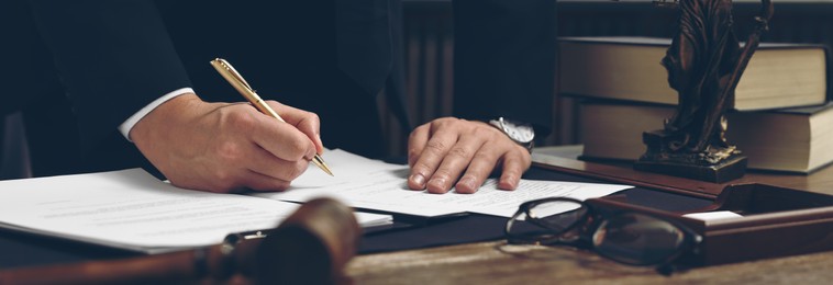 Image of Lawyer working with document at wooden table in office, closeup. Banner design