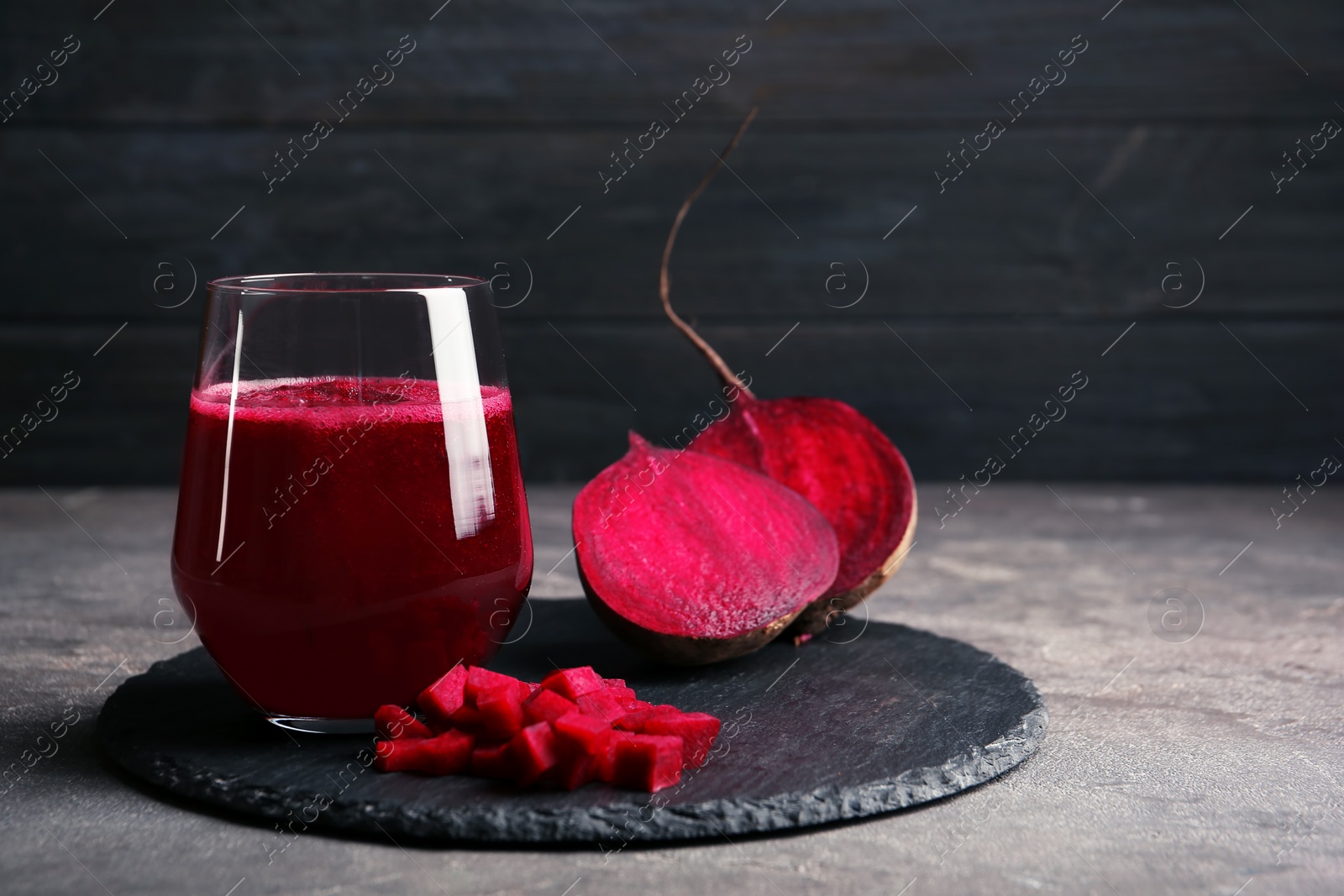 Photo of Slate plate with glass of beet smoothie on table