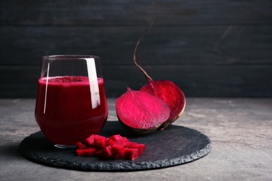 Photo of Slate plate with glass of beet smoothie on table