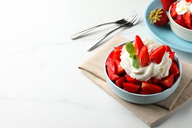 Photo of Delicious strawberries with whipped cream served on white table. Space for text
