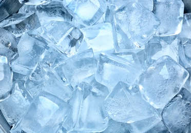 Photo of Many ice cubes on color background, top view