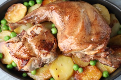 Tasty cooked rabbit with vegetables in baking dish on table, top view