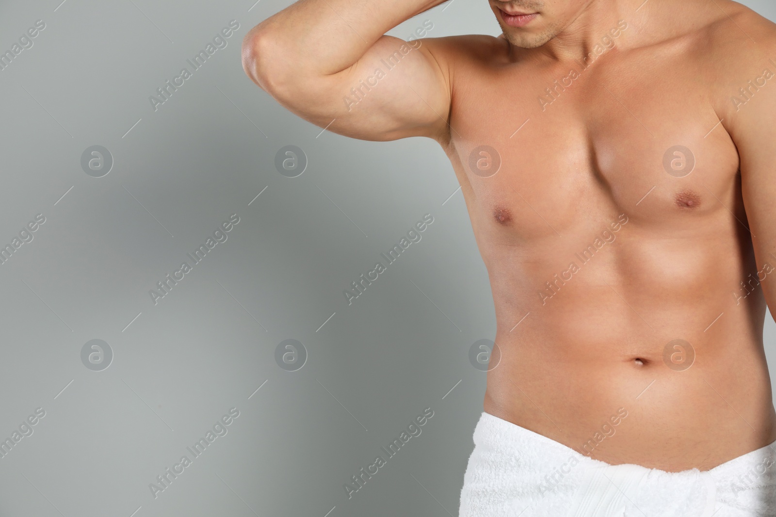 Photo of Young man with slim body on grey background, closeup view. Space for text