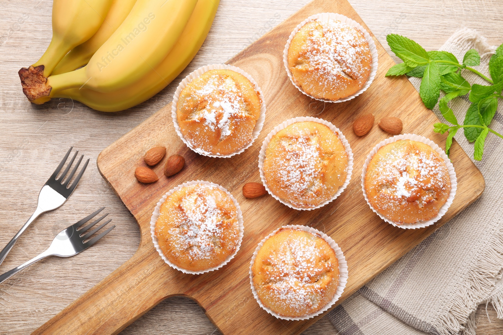 Photo of Flat lay composition with tasty banana muffins on wooden table