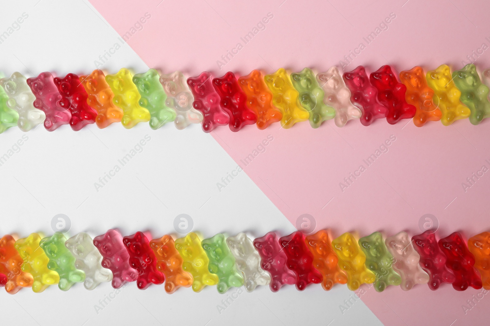 Photo of Delicious little jelly bears on color background, top view. Space for text