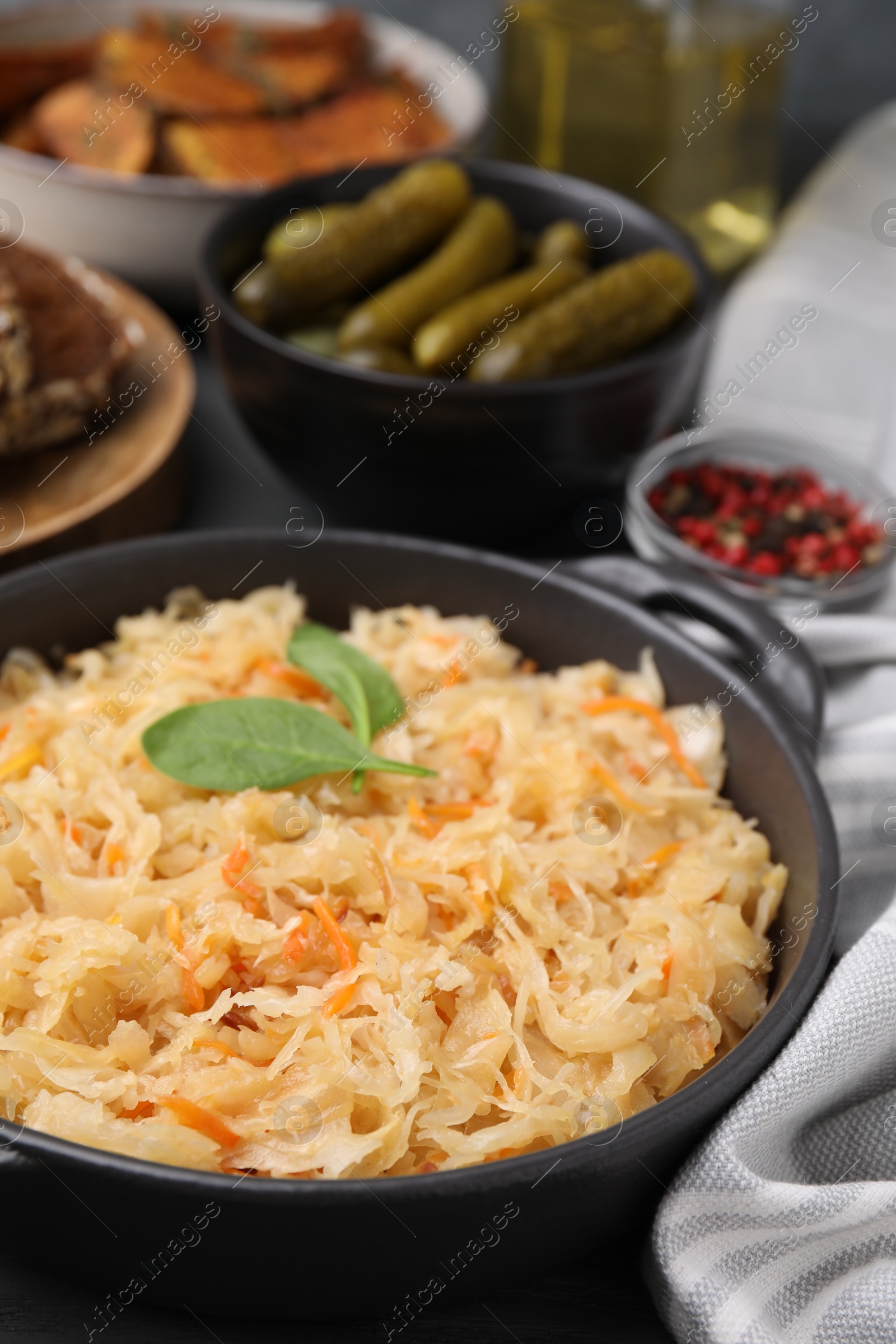 Photo of Serving pan with sauerkraut on table, closeup