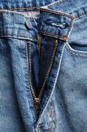 Photo of Blue jeans with unbuttoned fly as background, top view. Exhibitionist concept