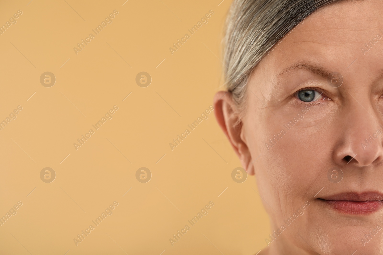 Photo of Woman with normal skin on beige background, macro view. Space for text