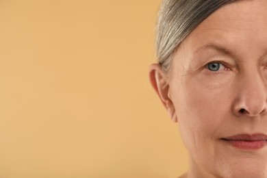 Woman with normal skin on beige background, macro view. Space for text