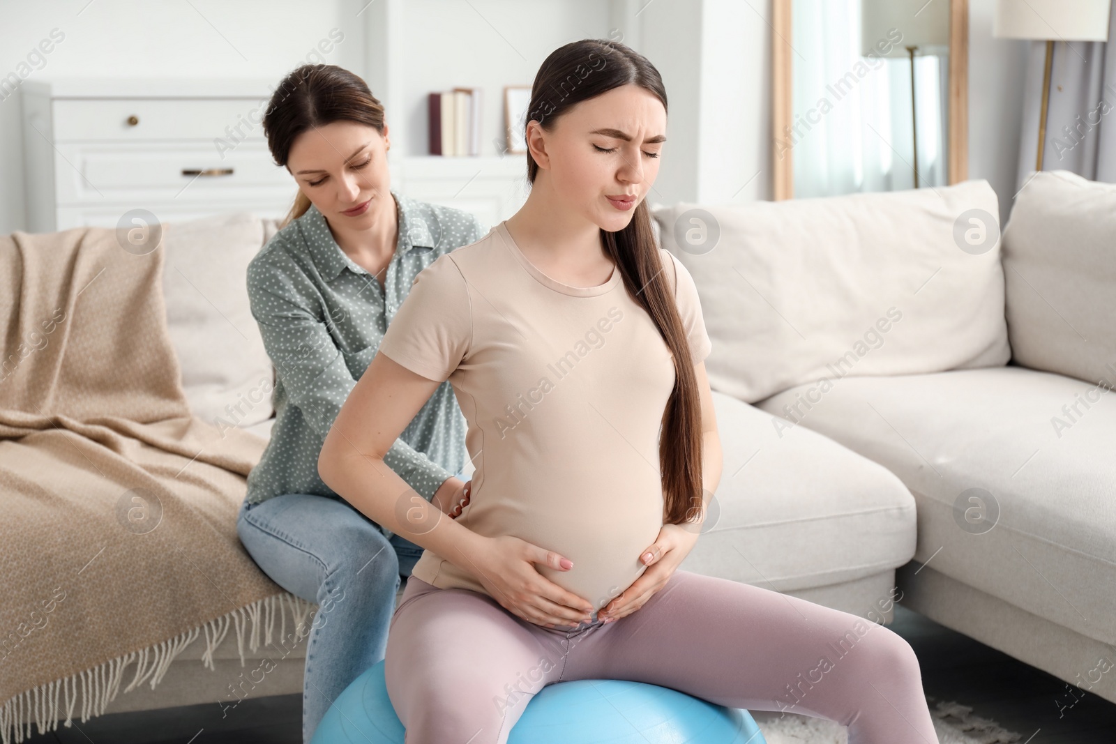 Photo of Doula working with pregnant woman at home. Preparation for child birth