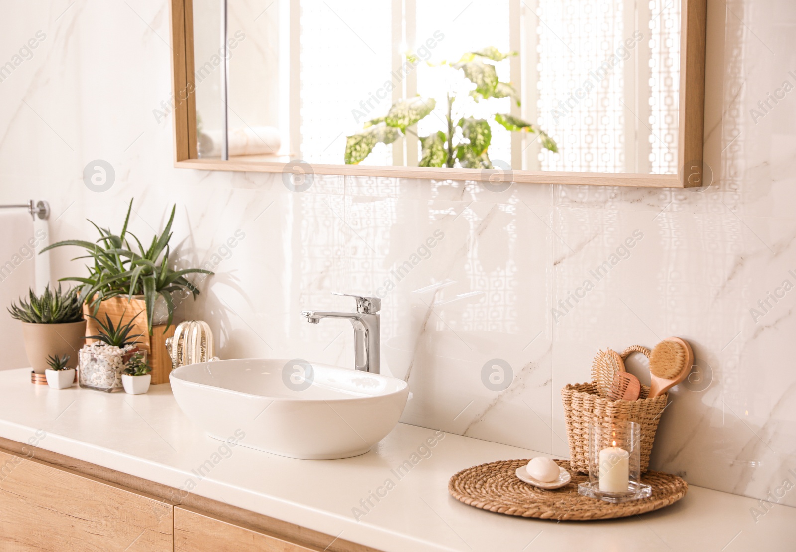 Photo of Stylish bathroom interior with countertop, mirror and houseplants. Design idea