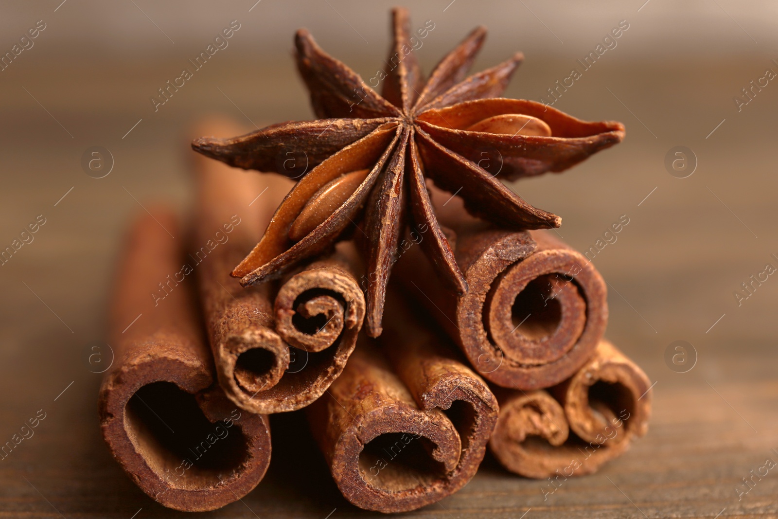 Photo of Cinnamon sticks with anise on wooden table