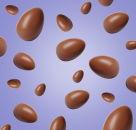 Image of Many chocolate eggs falling on pale violet background