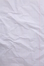 Sheet of crumpled checkered paper as background, top view