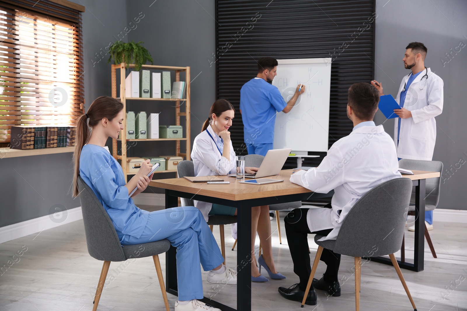 Photo of Team of professional doctors having meeting in office