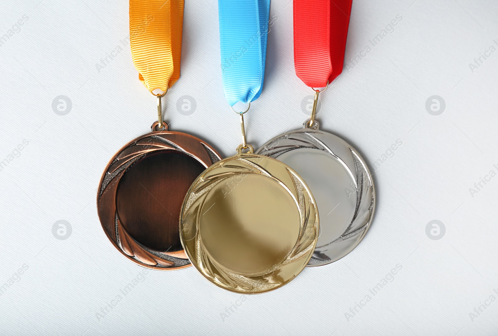 Photo of Gold, silver and bronze medals on white background, flat lay. Space for design