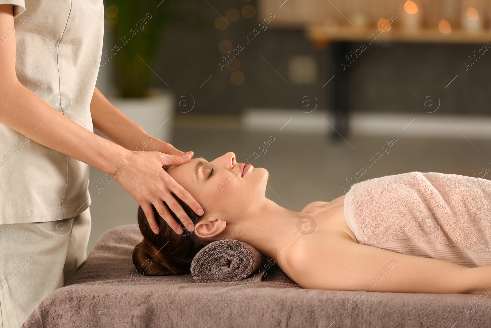 Photo of Beautiful young woman enjoying massage in spa salon