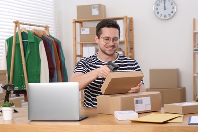 Photo of Seller with parcels working in office. Online store