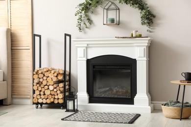 Photo of Stylish room decorated with beautiful eucalyptus garland above fireplace