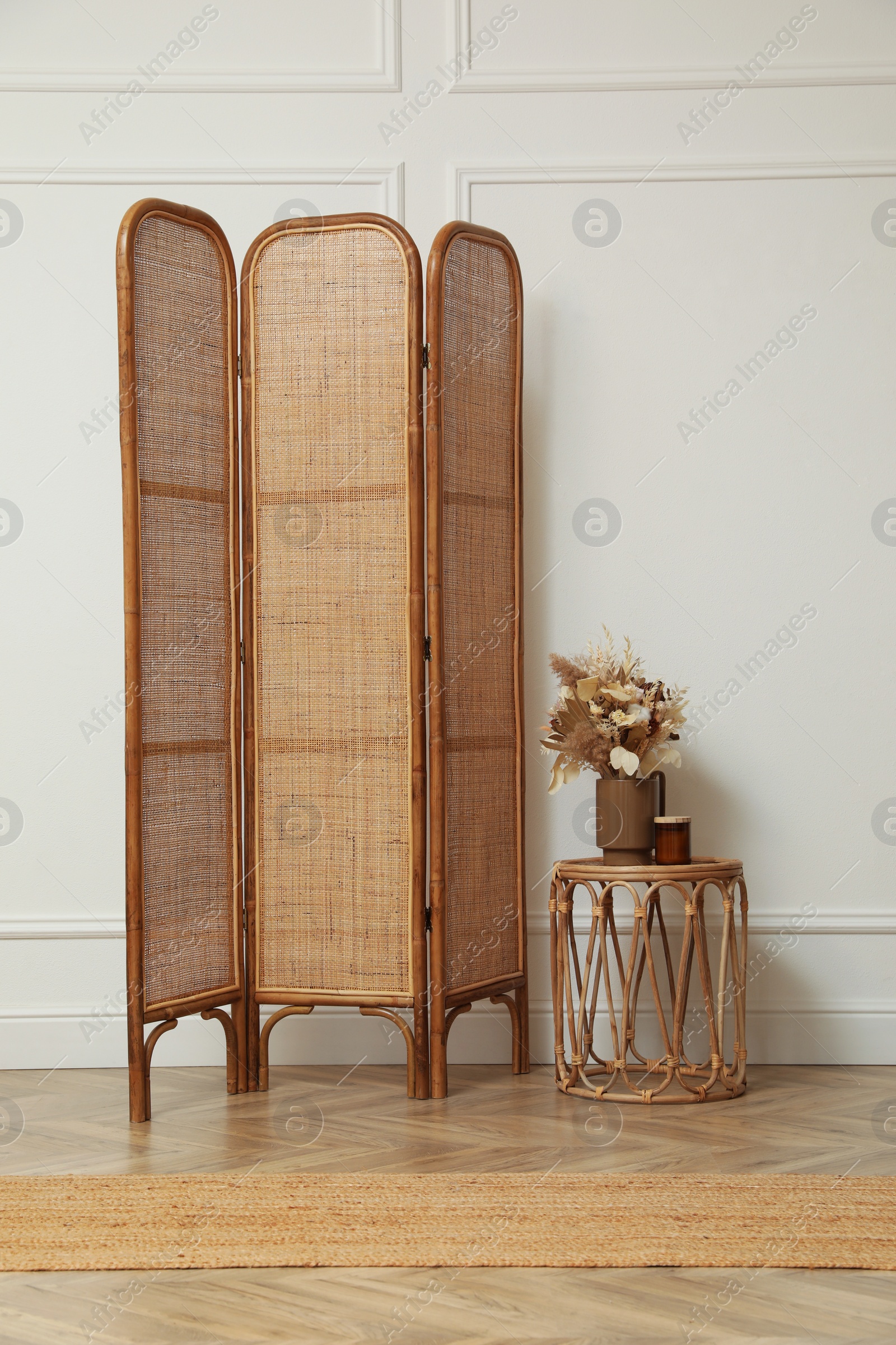 Photo of Folding screen and small table with flowers in room. Interior design