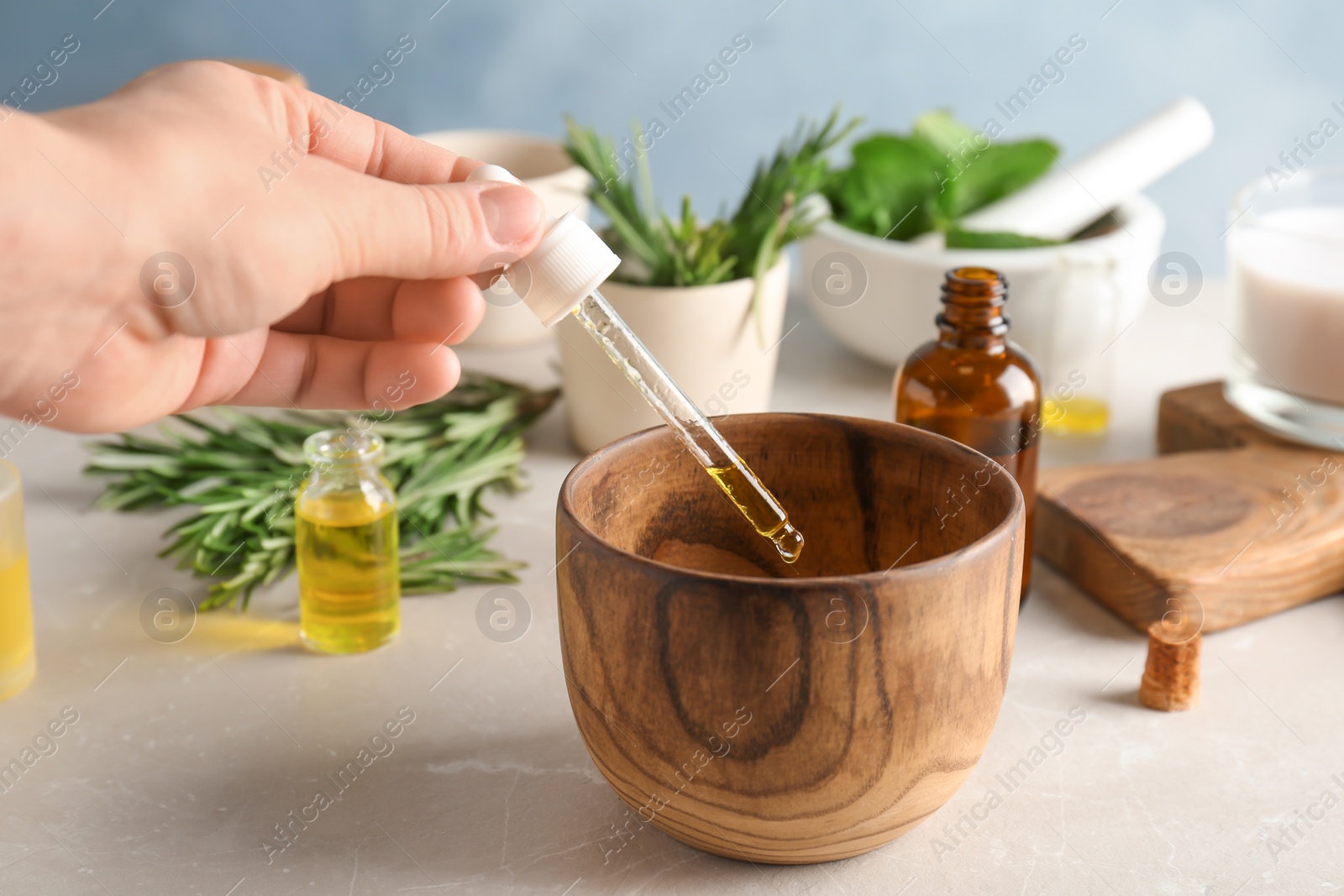 Photo of Woman dropping essential oil into bowl