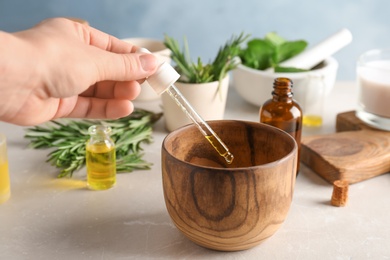 Photo of Woman dropping essential oil into bowl