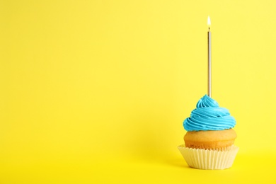 Birthday cupcake with candle on yellow background, space for text