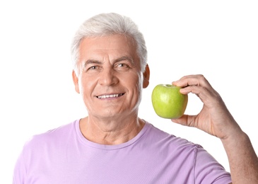 Photo of Mature man with healthy teeth and apple on white background