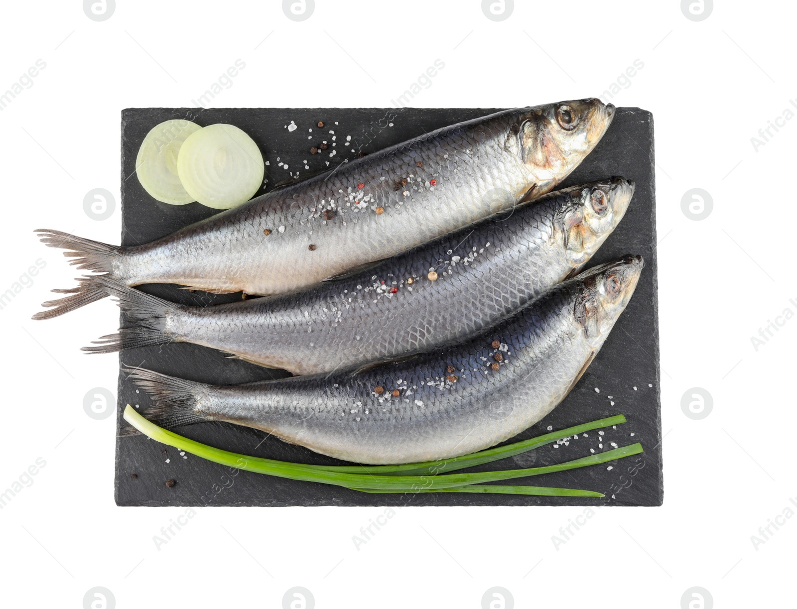 Photo of Slate plate with salted herrings, spices and onion isolated on white, top view