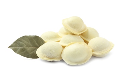 Photo of Pile of raw dumplings with bay leaf on white background