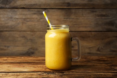 Mason jar with delicious fruit smoothie on wooden table