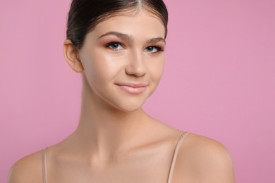 Photo of Pretty girl on pink background. Beautiful face with perfect smooth skin