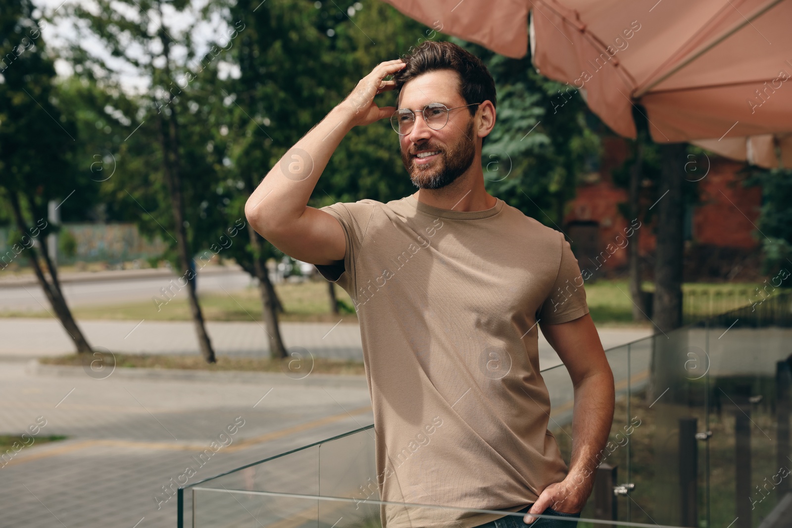 Photo of Handsome bearded man looking away outdoors. Space for text