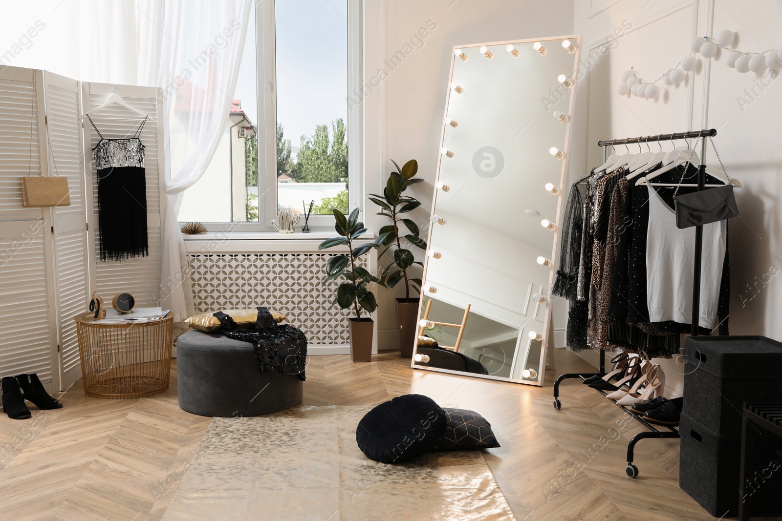 Photo of Stylish dressing room interior with trendy clothes and shoes